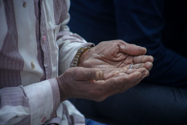 Close-up of elderly hands cupped together in a contemplative pose, evoking emotions.