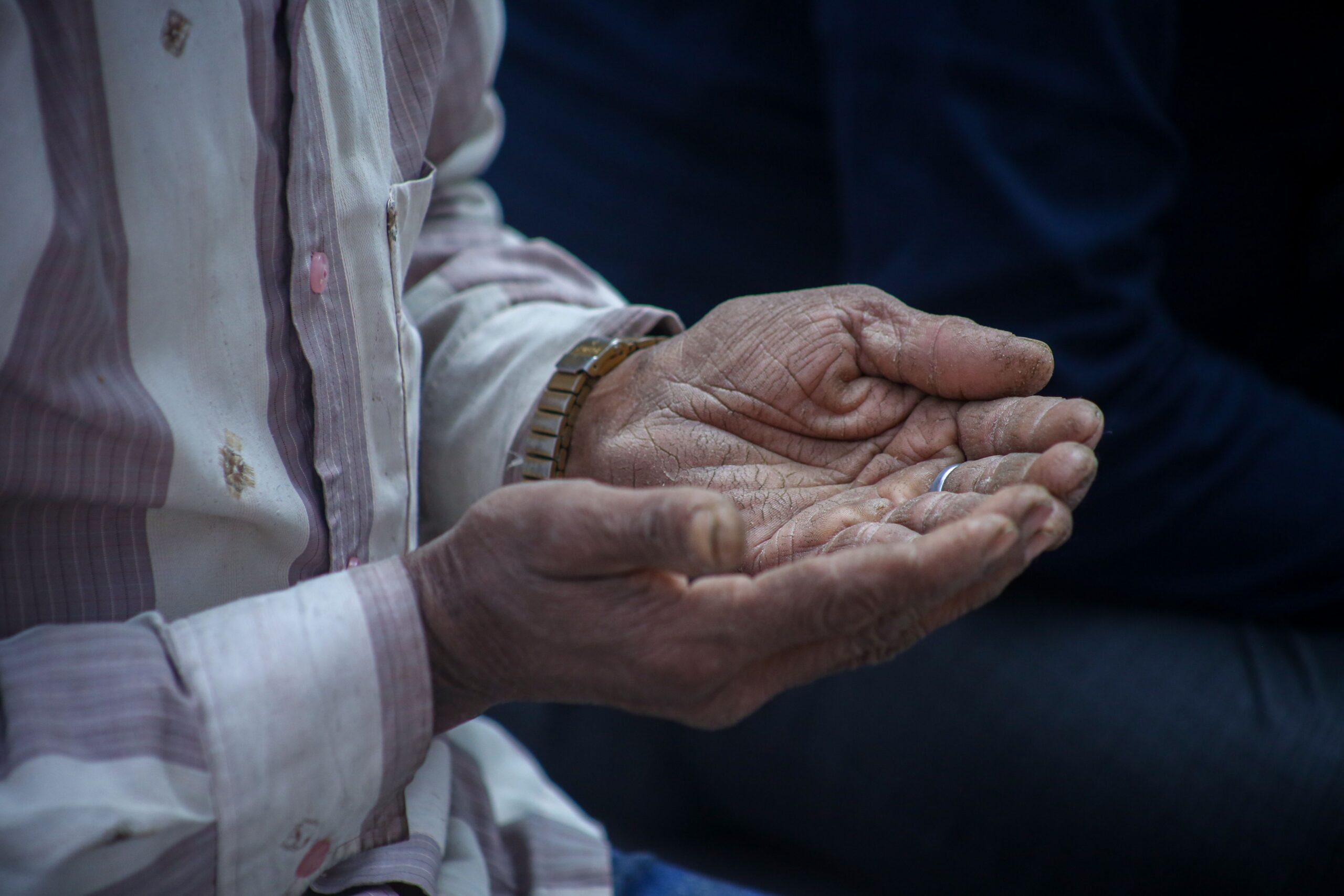 Close-up of elderly hands cupped together in a contemplative pose, evoking emotions.