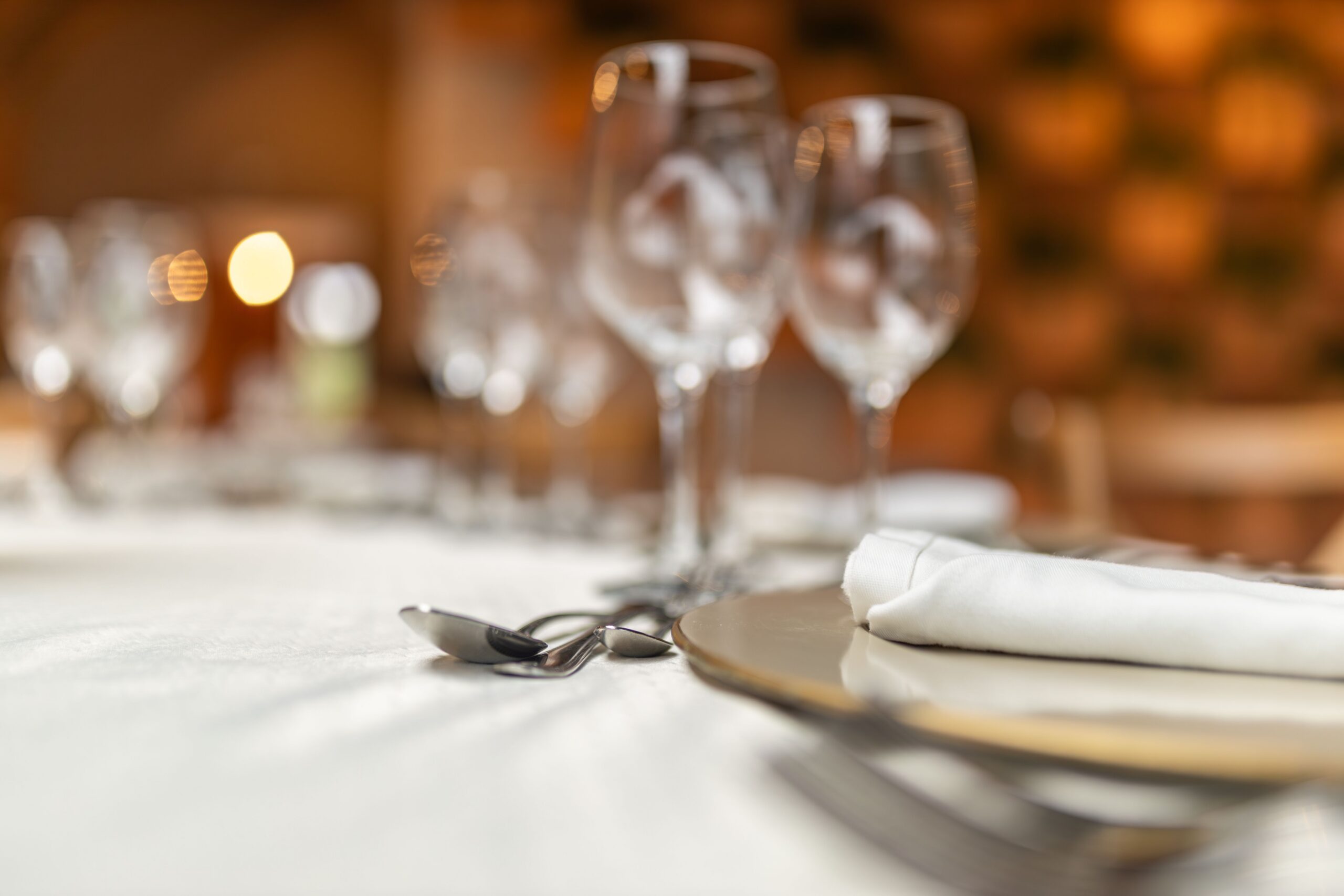 Close-up of a sophisticated restaurant table setting with wine glasses and tableware.